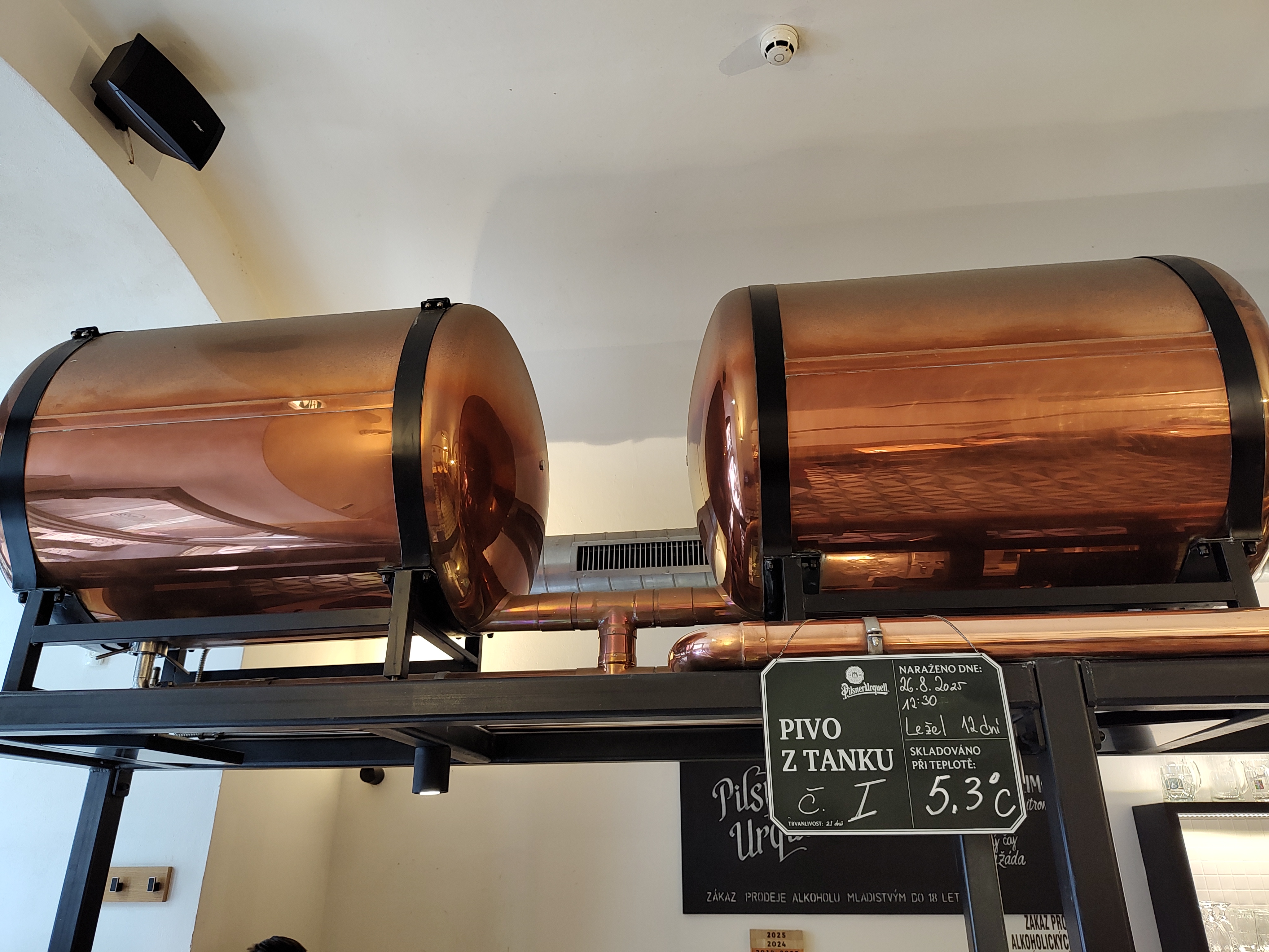 Tanques de cerveza Pilsner Urquell con su cartel informativo en un restaurante de Praga