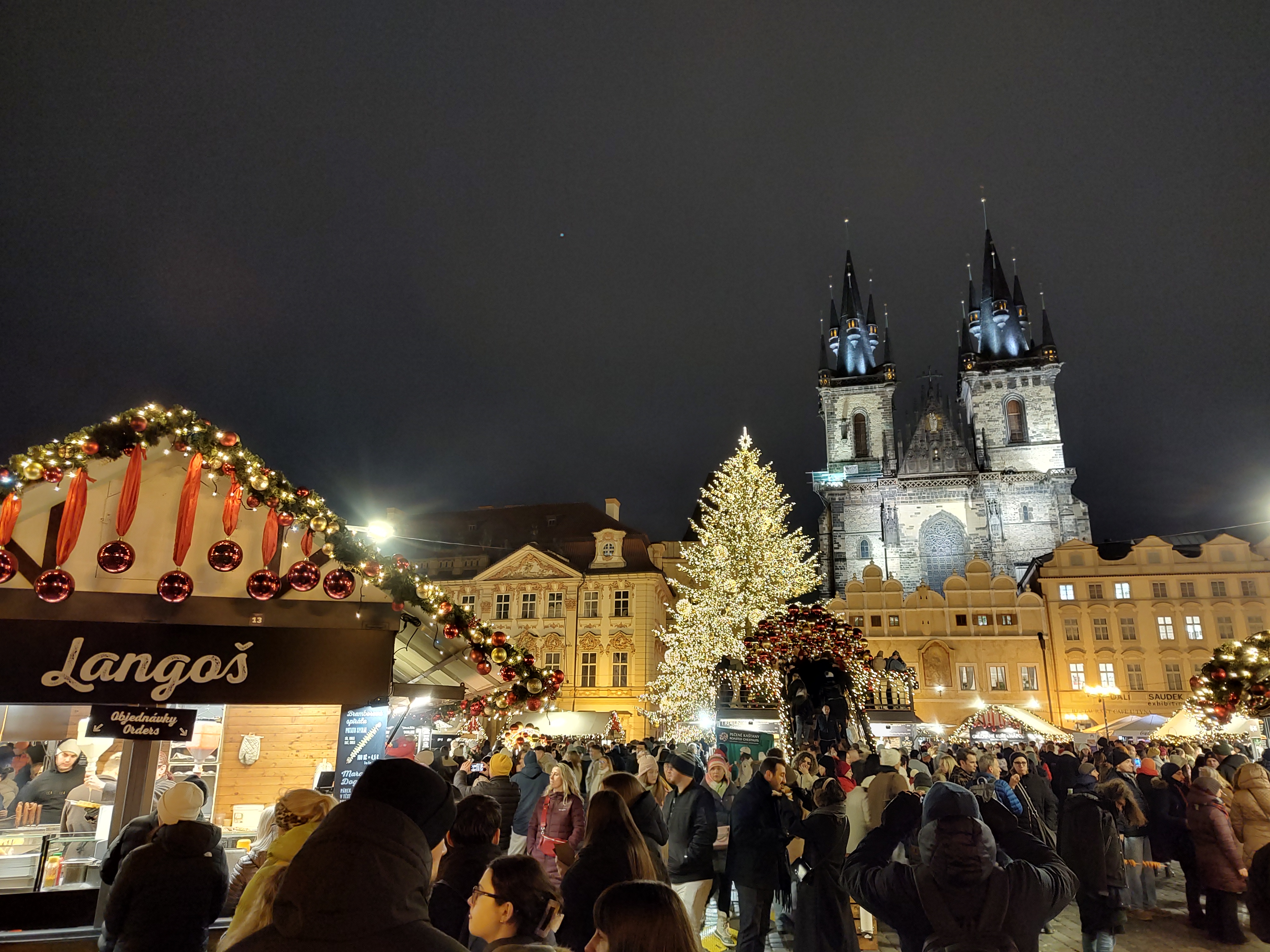 Puestos de mercadillos navideños en la plaza de la ciudad vieja de Praga con luces y decoración